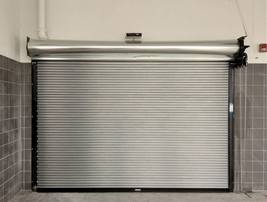 Metal roll-up fire door in a commercial space with safety features and secure access.